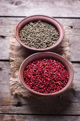 Red and green pepper  in bowls on  vintage wooden background.