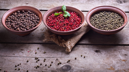 Different  pepper  in bowls on wooden background