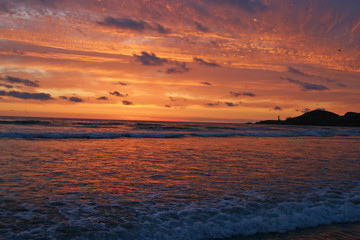 Fototapeta na wymiar Glorious sunset Over Lighthouse and Sea
