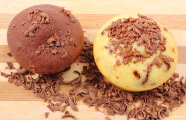 Fresh baked muffins and grated chocolate on wooden cutting board