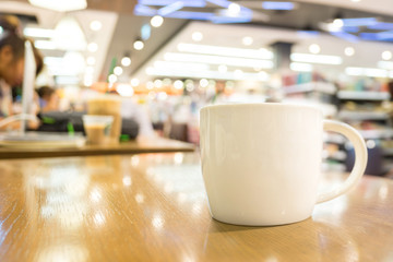 Coffee cup on wood table in cafe with blur background, Leisure l