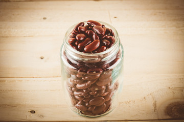 red  beans on wood background - soft focus with vintage film fil