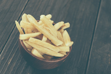 french fries on wood background - soft focus with vintage film f