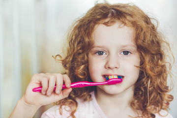 Portrait of the little girl brushing her teeth