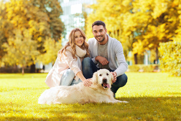 happy couple with labrador dog autumn in park