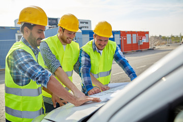 close up of builders with blueprint on car hood