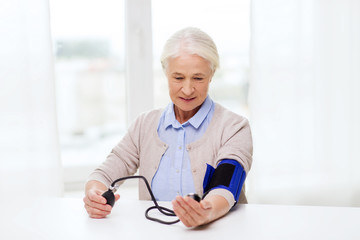 old woman with tonometer checking blood pressure