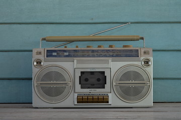Retro cassette tape recorder and tape cassette player on wooden background