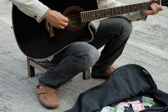 Close-up Of Street Musician Playing Guitar For Money, Concept About People And Street Art