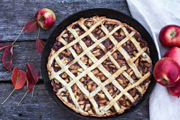 Homemade pie with apples on black wooden background in country style