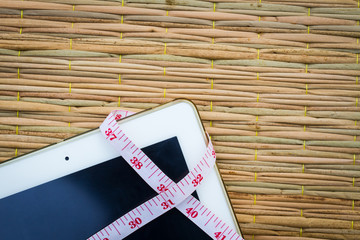 tablet computer on traditional mat with  measuring tape 