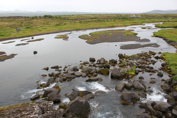 Ein See mit Steinen im Nationalpark Thingvellir auf Island