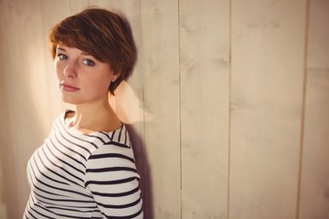 Pretty young woman backed on wall