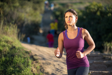 Fototapeta premium Athlete woman running in nature jogging path determined serious focused mental strength