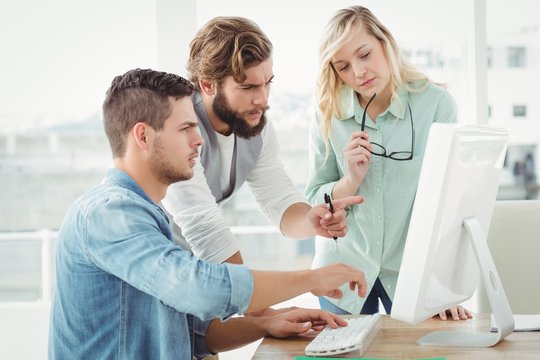 Business people discussing by computer 