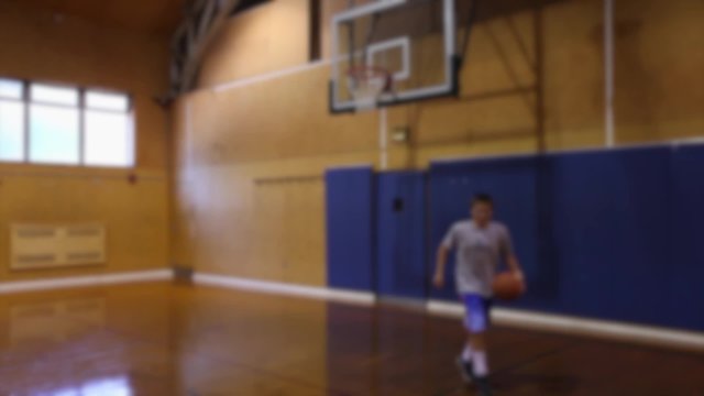 Boy playing indoor basketball alone