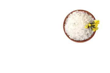 sea salt and yellow flowers in a wooden bowl isolated on white background