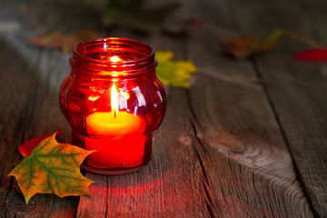 Cemetery red lantern candle with autumn leaves in night