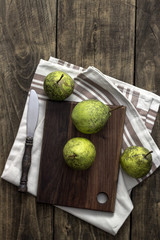 fresh pears on wooden cutting board