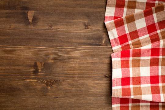 Checkered napkin at right side  of wooden background