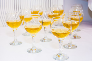 Glasses with wine, the alcohol poured into glasses, white tablecloth with a table setting, table Setting in the restaurant.