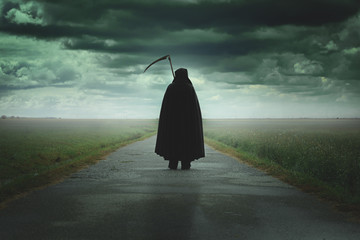 Grim reaper walking a desolate road