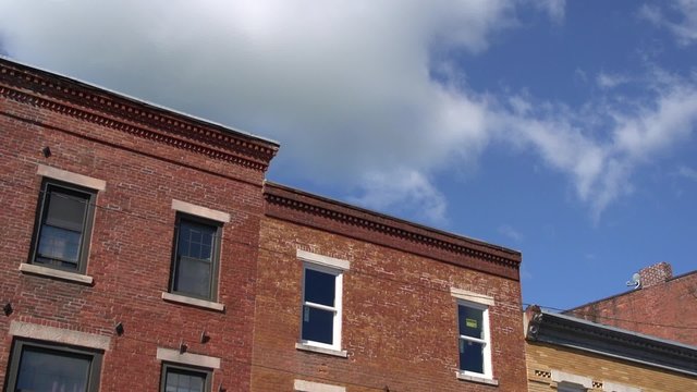 Puffy clouds over a brick building