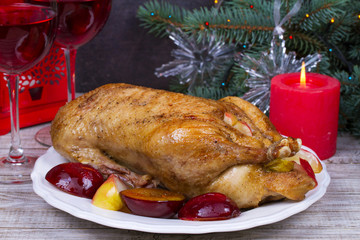 Festive Christmas duck baked with apples and plums: glasses of wine