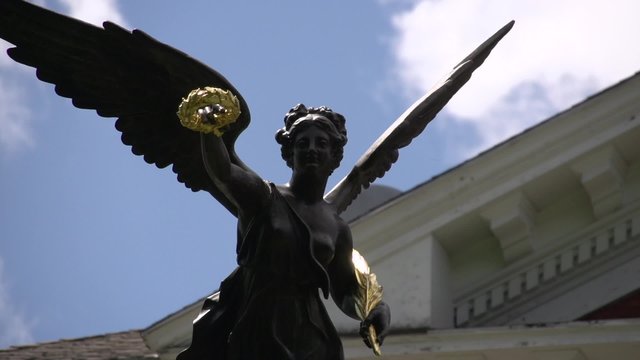 Statue of woman with wreath and wings
