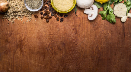 Border with autumn vegetables, mushrooms and nuts raisin couscous mushrooms herbs and garlic on rustic wooden background top view banner