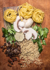 chopped walnuts, raisins, mushrooms, herbs concept cooking  on a cutting board on wooden background top view