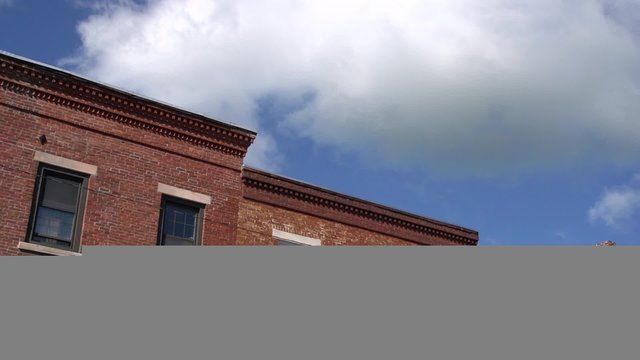 Puffy clouds over a brick building