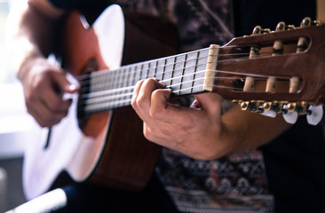 Fototapeta premium Close-up of hands on the guitar strings.