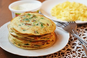 Pancakes with herbs and mushrooms and scrambled eggs for breakfast