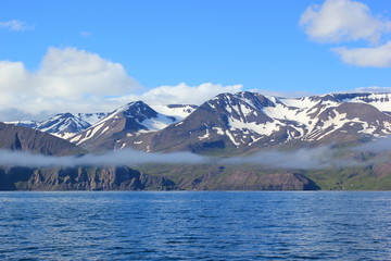 Blick auf die mit Schnee bedeckten Berg entlang der Bucht von Akureyri auf Island