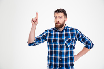 Fototapeta premium Portrait of a thoughtful casual man pointing finger up