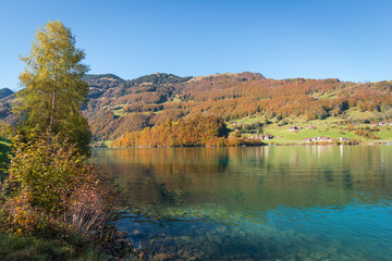 Switzerland. Autumn landscape with reflection in the water. Gorgeous sunny day.