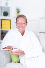 Hübsche Frau entspannt mit einer Tasse Kaffee auf der Couch