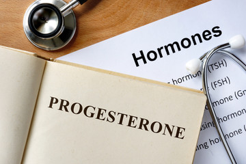Progesterone  word written on the book and hormones list.