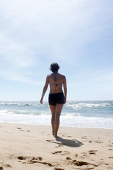Fototapeta na wymiar woman walking on the beach