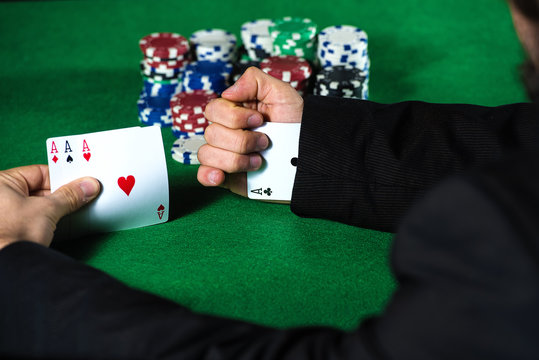 Man with ace up his sleeve, cheating at poker.