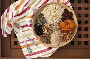 Healthy breakfast. Granola with nuts, seeds, honey, frozen raspberries pumpkin in a wooden biwk on wooden table
