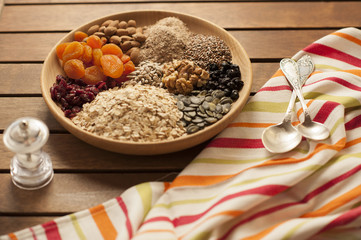 Healthy breakfast. Granola with nuts, seeds, honey, frozen raspberries pumpkin in a wooden biwk on wooden table