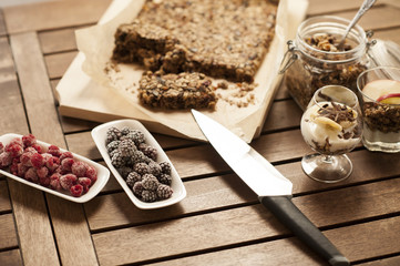 Healthy breakfast. Granola with nuts, seeds, honey, frozen raspberries pumpkin in a wooden biwk on wooden table