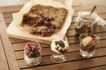 Healthy breakfast. Granola with nuts, seeds, honey, frozen raspberries pumpkin in a wooden biwk on wooden table