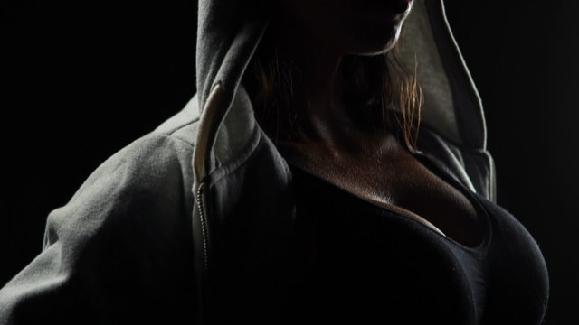 Muscular woman wearing grey hood 