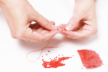 Stringing beads on a needle
Нанизывание бисера на иголку - obrazy, fototapety, plakaty