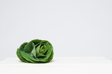 Fototapeta premium fresh green cabbage plant on a white crate