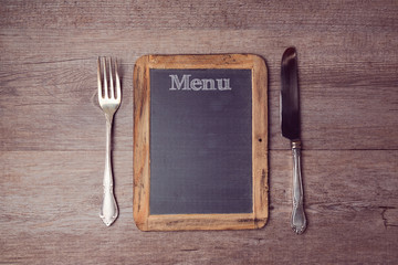 Creative menu background with chalkboard and silverwear. View from above
