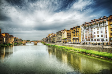 Fototapeta na wymiar Arno river under a dramatic sky in Florence